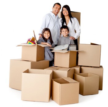 A family of four, consisting of a man, woman, and two children, standing amidst numerous open and sealed cardboard boxes filled with household items in a well-lit indoor setting. The boxes contain various possessions such as colorful books, small household objects, and packing materials, positioned in a semi-circle around the family. The man and woman are smiling, with the man wearing a white shirt and the woman in a white blouse, reflecting a positive moment during a home move. The children, a girl and boy, are also smiling and appear engaged in the packing process. The background shows a neutral interior environment, suggesting a typical residential property in Hampstead or nearby areas. The scene captures the preparation or packing stage of house removals, with the focus on efficiently loaded moving boxes and the family’s involvement in the process. Hampstead Man with Van’s domestic removals service context is subtly supported by the scene’s focus on household packing activities, emphasizing careful handling and organization typical of local house removals in the Hampstead area.